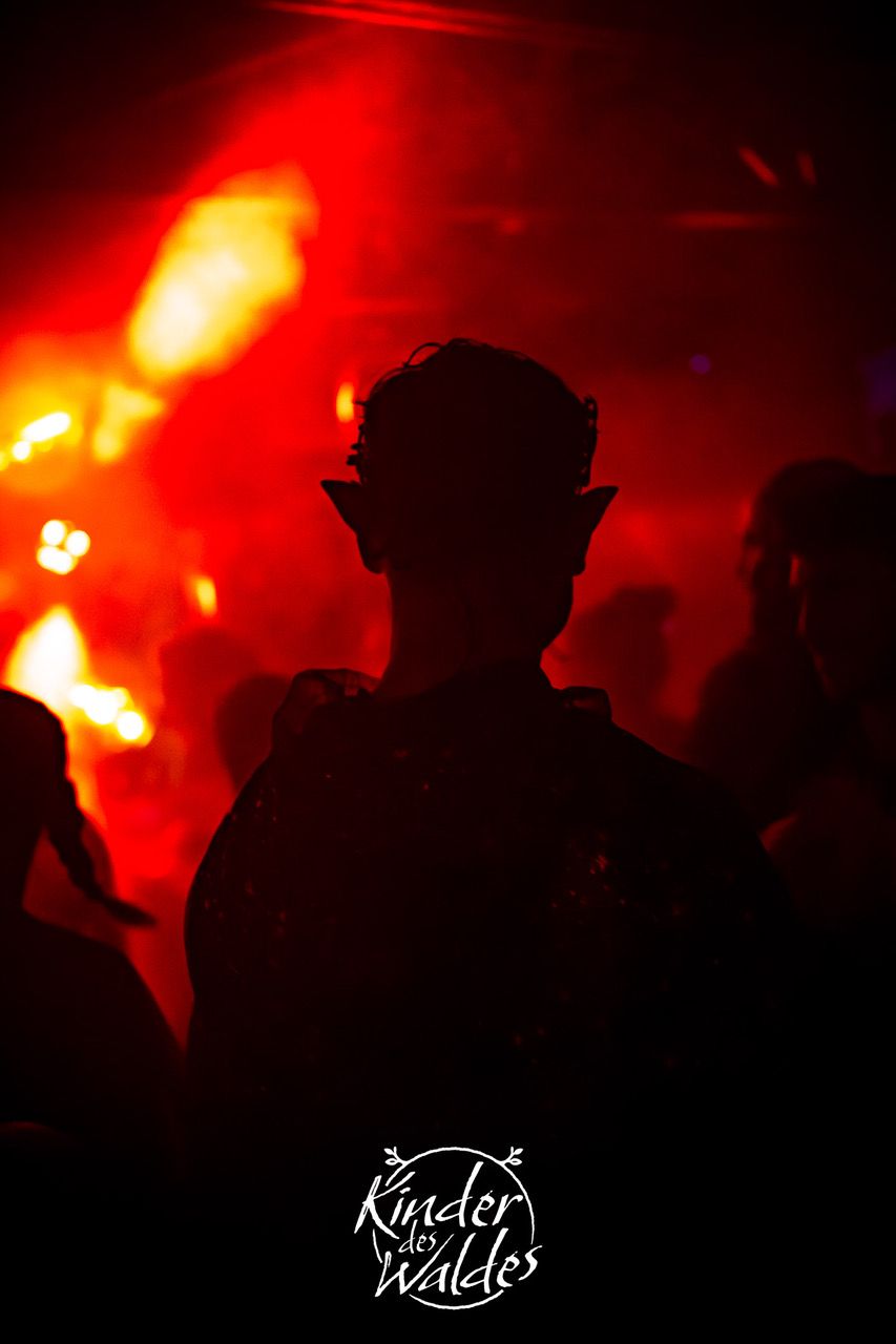 Silhouette mit Elfenohren vor rotem Bühnenlicht